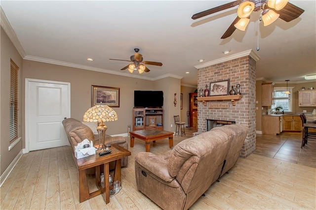 living room featuring ornamental molding, a fireplace, and light hardwood / wood-style floors