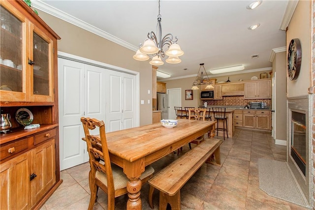 tiled dining area featuring a notable chandelier and crown molding