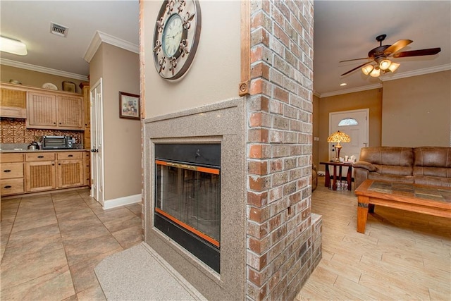 living room featuring a brick fireplace, crown molding, ceiling fan, and light wood-type flooring