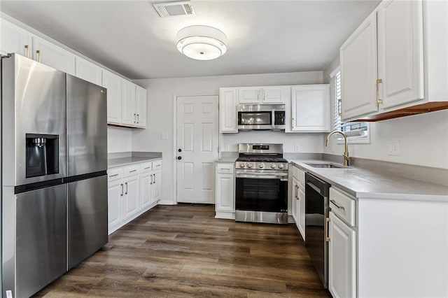 kitchen with white cabinetry, stainless steel appliances, dark hardwood / wood-style floors, and sink