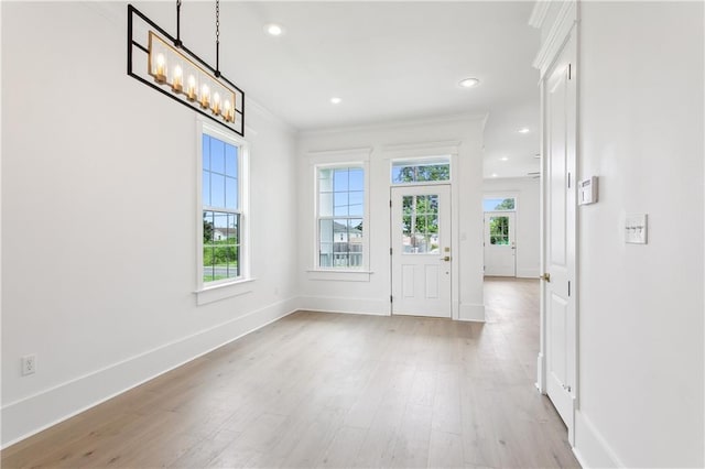 entryway with crown molding and light hardwood / wood-style floors