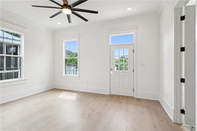 foyer entrance with ceiling fan, ornamental molding, and light hardwood / wood-style flooring