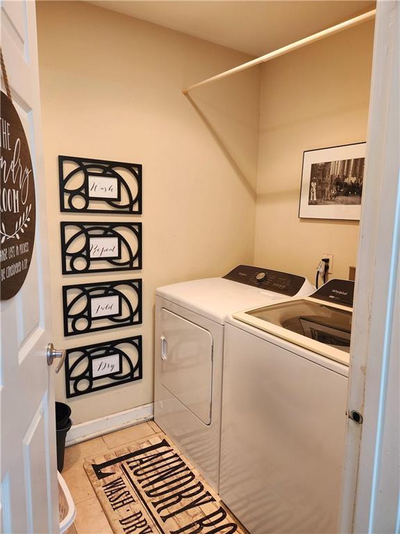 laundry area with washing machine and dryer and light tile patterned flooring