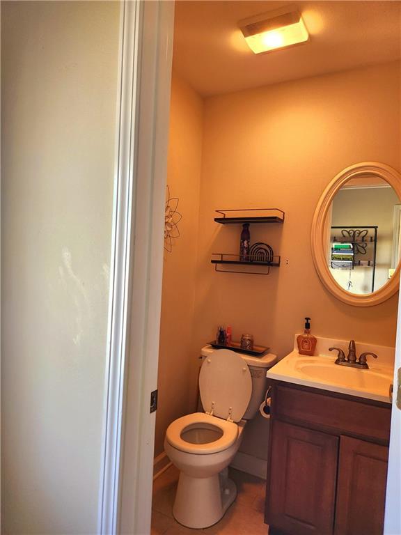 bathroom featuring tile patterned flooring, vanity, and toilet