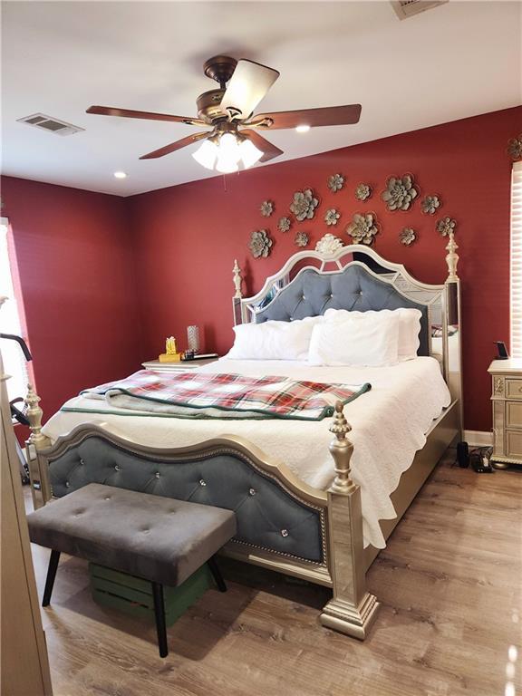 bedroom with wood-type flooring and ceiling fan