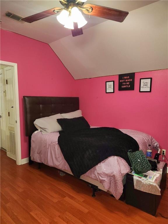 bedroom with hardwood / wood-style flooring, ceiling fan, and vaulted ceiling