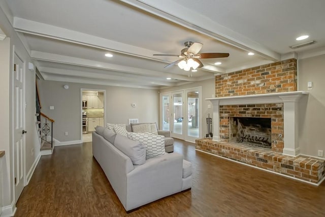 living room with a brick fireplace, beam ceiling, dark wood-type flooring, and french doors