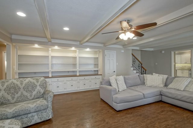 living room with ceiling fan, dark wood-type flooring, and beamed ceiling