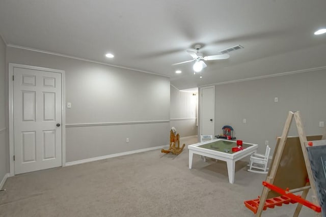 rec room with ornamental molding, carpet flooring, and ceiling fan