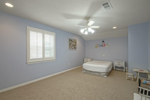 carpeted bedroom featuring ceiling fan, vaulted ceiling, and a textured ceiling