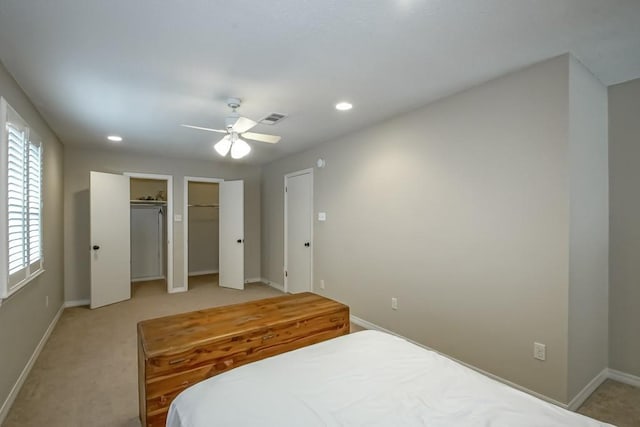 carpeted bedroom with multiple closets and ceiling fan