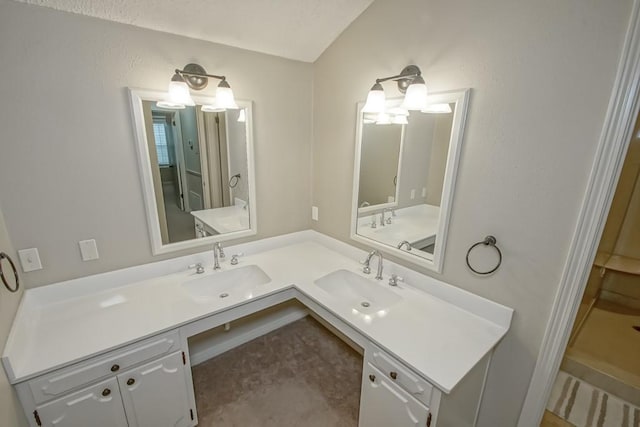 bathroom featuring vanity and lofted ceiling