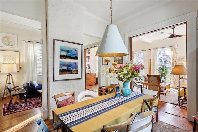 dining area with wood-type flooring and ornamental molding