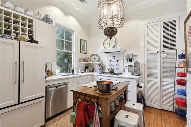 kitchen featuring white cabinetry, sink, light hardwood / wood-style floors, stainless steel appliances, and crown molding