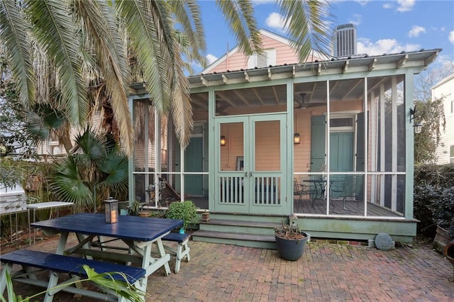 rear view of property featuring a patio, a sunroom, central AC unit, and french doors