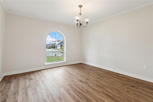 unfurnished room featuring crown molding, wood-type flooring, and a notable chandelier