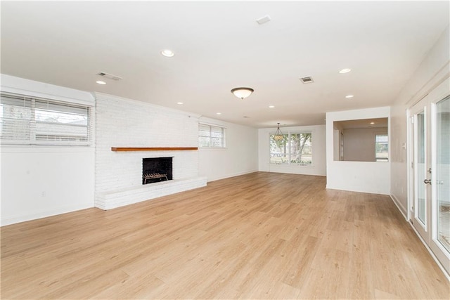 unfurnished living room featuring a fireplace and light hardwood / wood-style floors