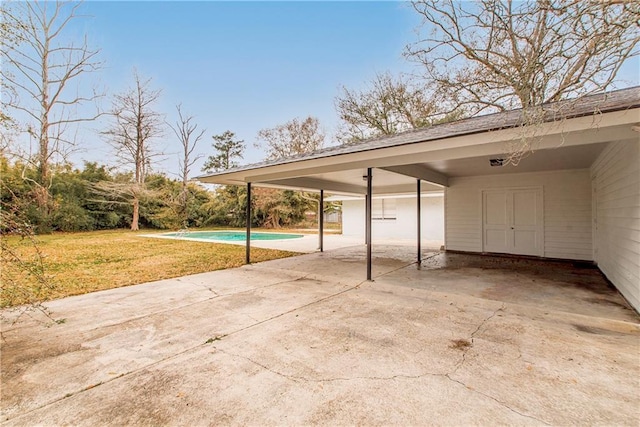 view of parking / parking lot featuring a carport and a yard