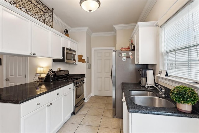 kitchen featuring appliances with stainless steel finishes, sink, white cabinets, light tile patterned floors, and crown molding