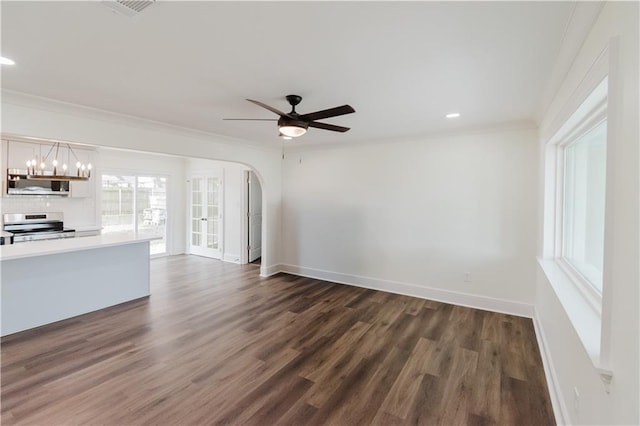 unfurnished living room featuring crown molding, dark hardwood / wood-style flooring, and ceiling fan with notable chandelier