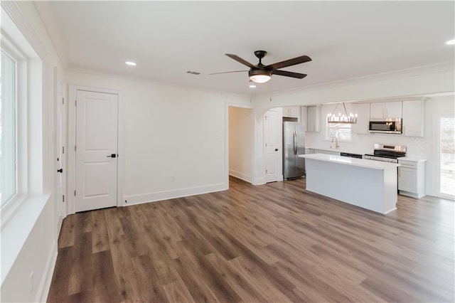 kitchen featuring white cabinetry, hardwood / wood-style flooring, stainless steel appliances, and a kitchen island