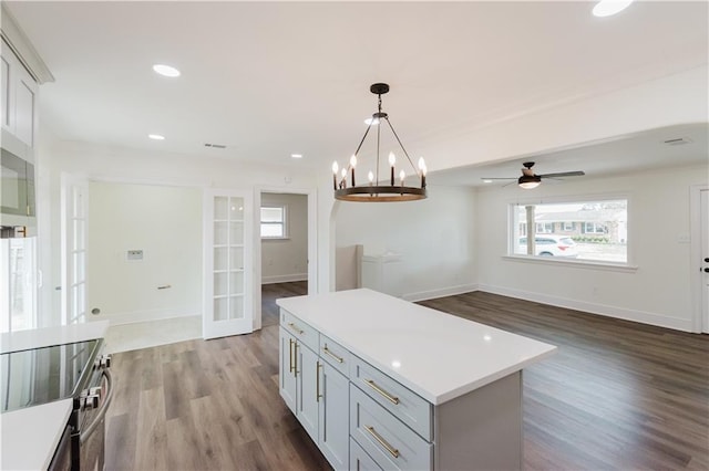 kitchen featuring french doors, a center island, hardwood / wood-style flooring, pendant lighting, and ceiling fan