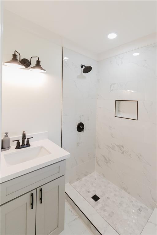 bathroom with vanity and a tile shower