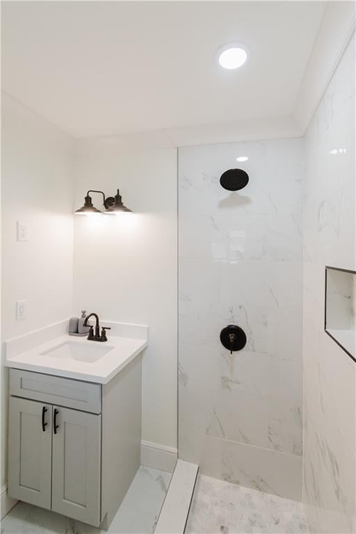 bathroom with a tile shower and vanity