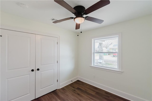 unfurnished bedroom with dark hardwood / wood-style flooring, a closet, and ceiling fan