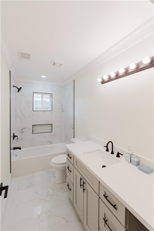 full bathroom with tiled shower / bath, vanity, and toilet