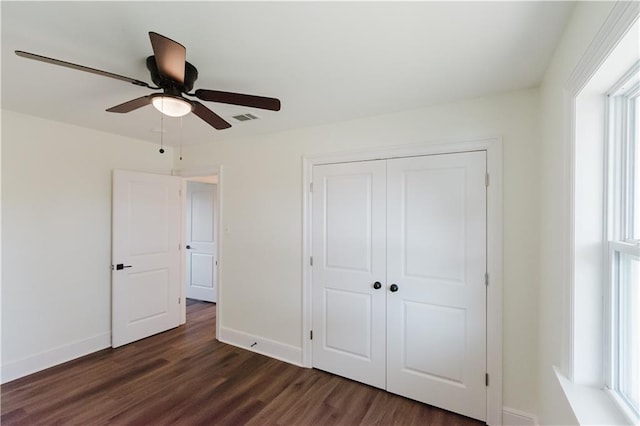 unfurnished bedroom featuring ceiling fan, dark hardwood / wood-style floors, and a closet