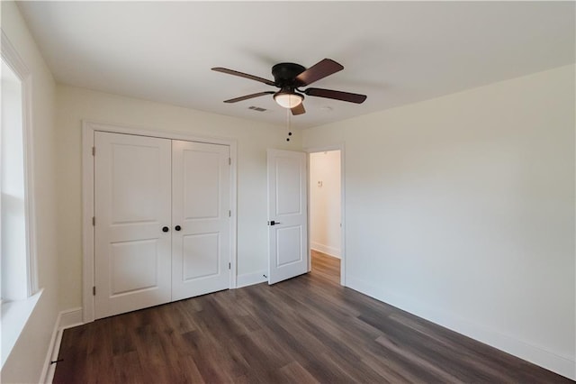 unfurnished bedroom with dark wood-type flooring, ceiling fan, and a closet