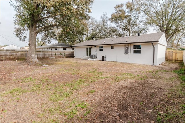 back of property featuring central AC and a yard