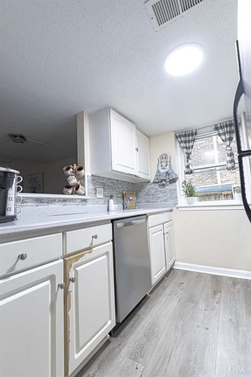 kitchen featuring dishwasher, light wood-type flooring, a textured ceiling, and white cabinets