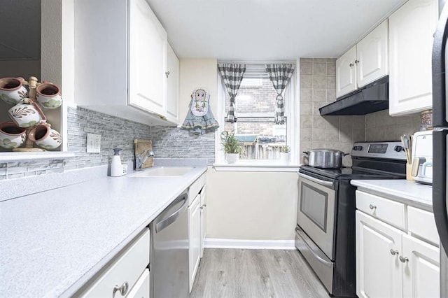 kitchen with sink, decorative backsplash, stainless steel appliances, and white cabinets