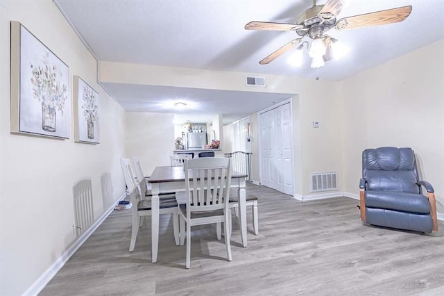 dining space with ceiling fan and light hardwood / wood-style floors