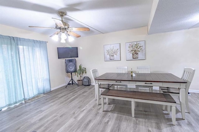 dining room featuring a textured ceiling, ceiling fan, and light hardwood / wood-style flooring