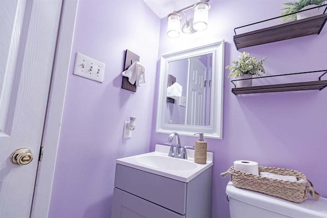 bathroom featuring vanity and toilet