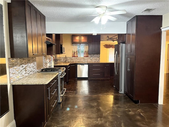 kitchen with tasteful backsplash, light stone countertops, a textured ceiling, and appliances with stainless steel finishes