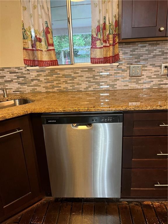 kitchen featuring light stone counters, stainless steel dishwasher, dark brown cabinetry, and decorative backsplash