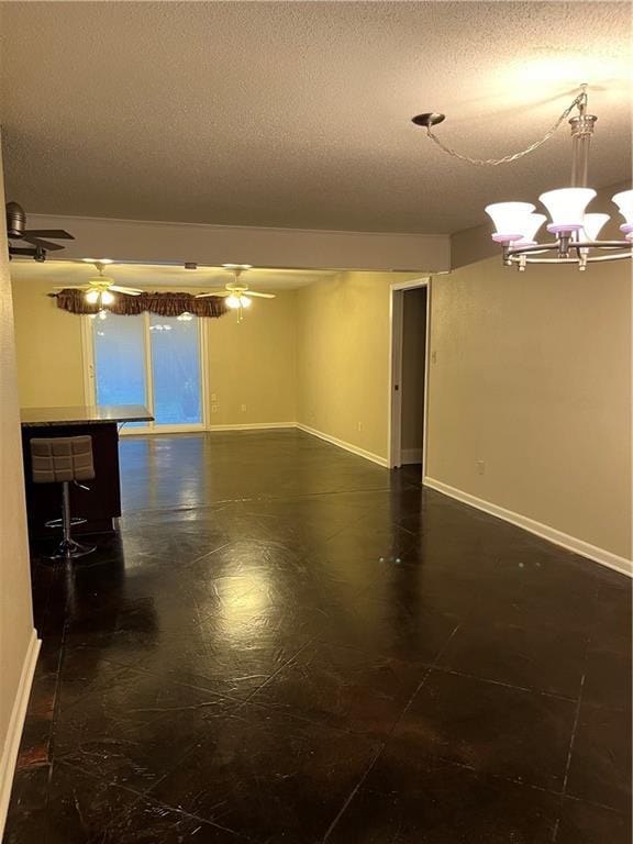 spare room with ceiling fan with notable chandelier and a textured ceiling