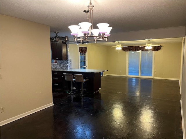 kitchen featuring tasteful backsplash, pendant lighting, a textured ceiling, and a kitchen breakfast bar