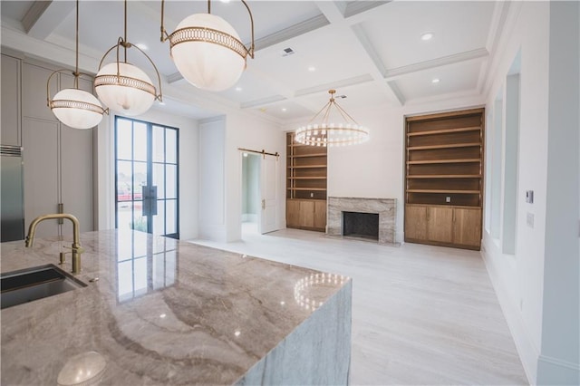 living room with sink, built in features, coffered ceiling, a barn door, and beamed ceiling