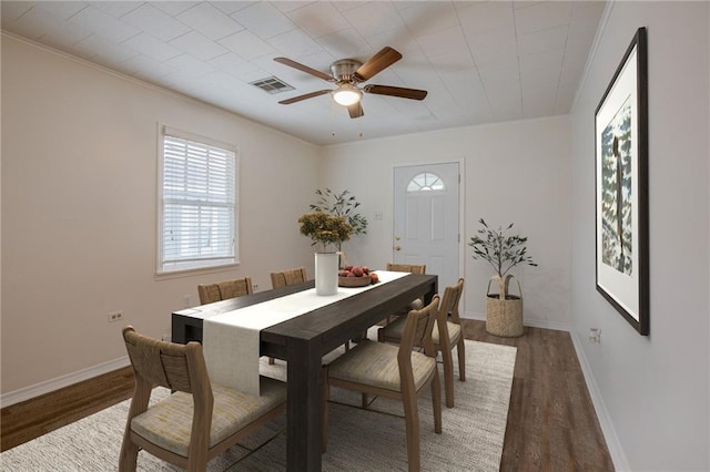 dining area featuring ceiling fan, ornamental molding, and dark hardwood / wood-style flooring