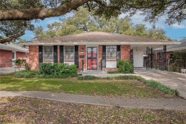 ranch-style home featuring a front lawn and a carport