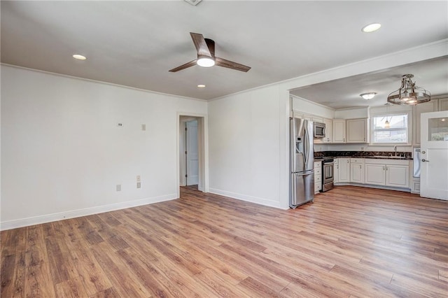 kitchen with sink, ornamental molding, ceiling fan, stainless steel appliances, and light hardwood / wood-style flooring