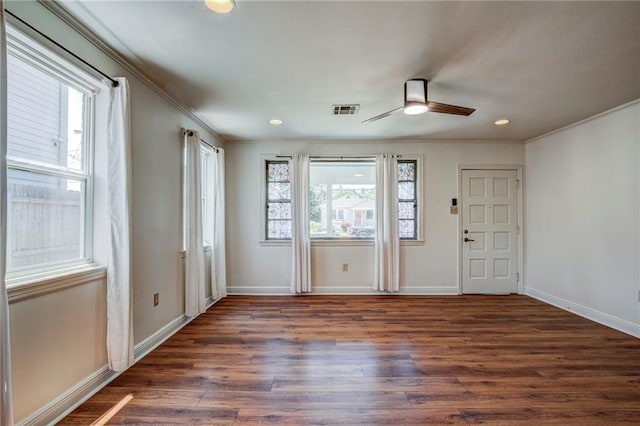 interior space with dark wood-type flooring, ornamental molding, and ceiling fan