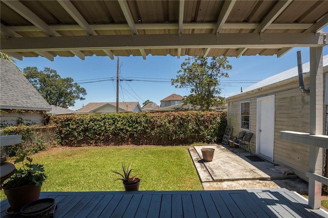 wooden terrace with a yard and a patio