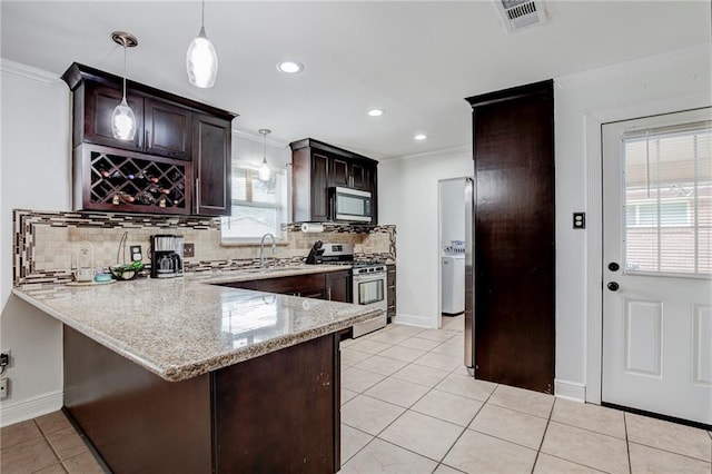 kitchen featuring decorative light fixtures, ornamental molding, kitchen peninsula, stainless steel appliances, and light stone countertops