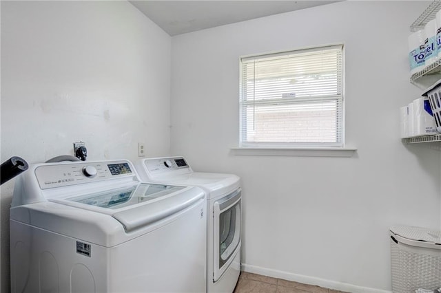 clothes washing area featuring washer and clothes dryer and light tile patterned flooring